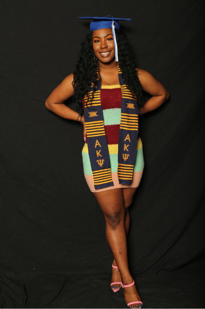 graduate in dress poses with her cap on